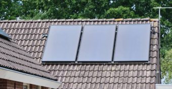 flat solar heat panels installed on the roof of a residential home, showcasing the integration of renewable energy in modern living. A demonstration of sustainable energy solutions in everyday environments